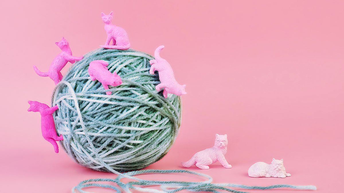 ball of yarn with pink plastic cats